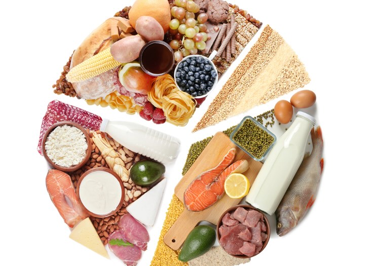 Gesunde Lebensmittel wie Obst, Gemüse, Getreide, Fisch, Milchprodukte und Hülsenfrüchte im Kreis angeordnet – Symbol für die neue ernährungsmedizinische Kochgruppe im MVZ Timmermann & Partner.