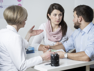 Arzt spricht mit Patient in der Sprechstunde und plant die Behandlung.