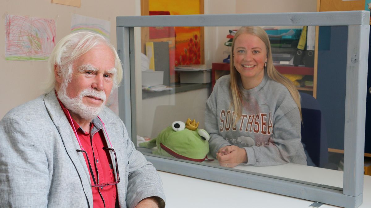Jochen Timmermann und Logopädin Sina Teyke im Gespräch über den Fachkräftemangel im Heilmittelbereich, getrennt durch eine Plexiglasscheibe.