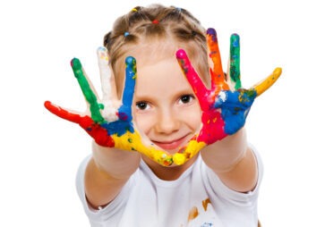 Mädchen zeigt bunt bemalte Hände – Symbolfoto für Kunsttherapie im MVZ Timmermann & Partner