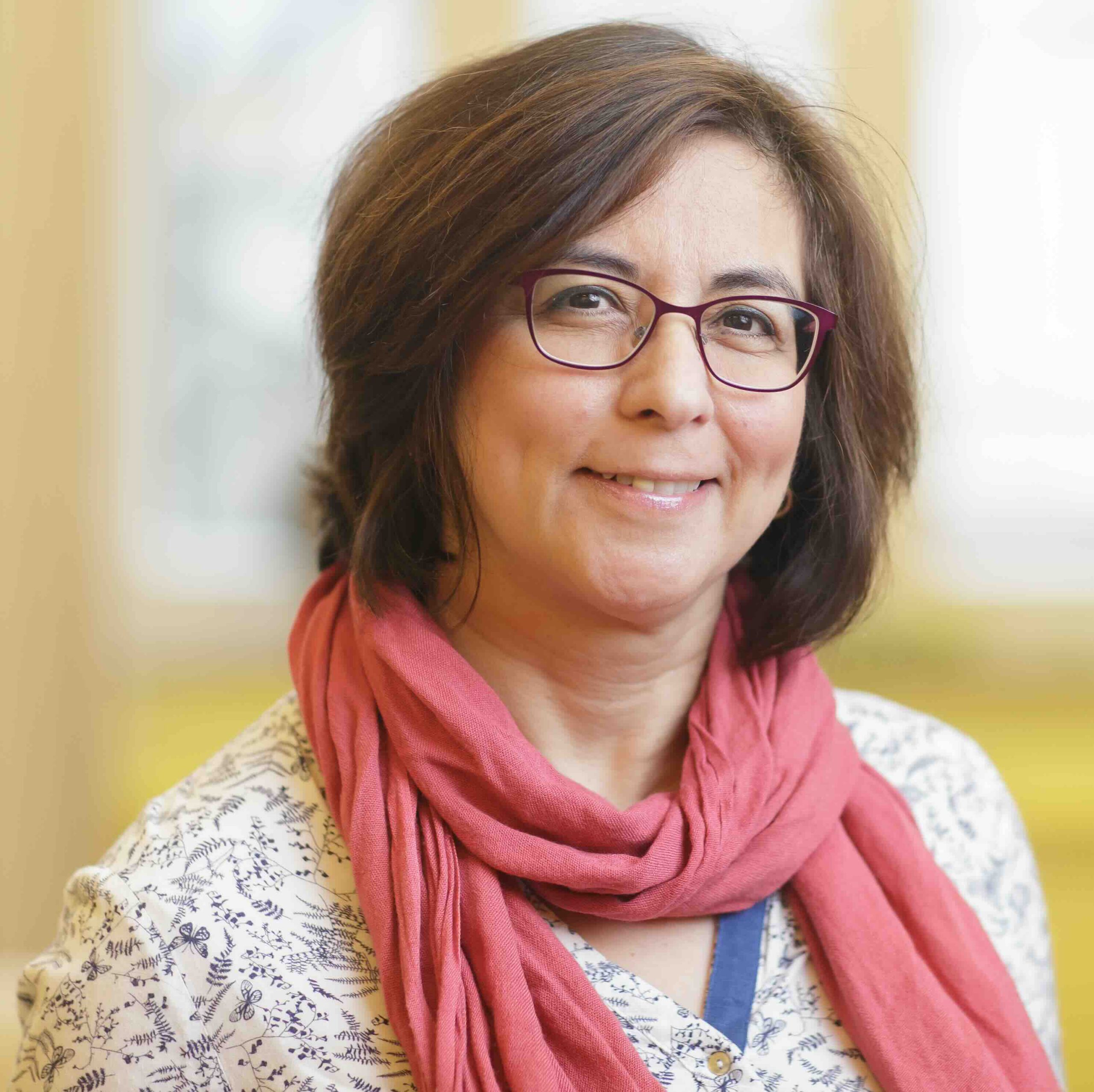 Porträt einer Frau mit Brille und rosa Schal, freundlich lächelnd vor hellem Hintergrund – Symbolbild für das NTFN und das Projekt „Morgenröte