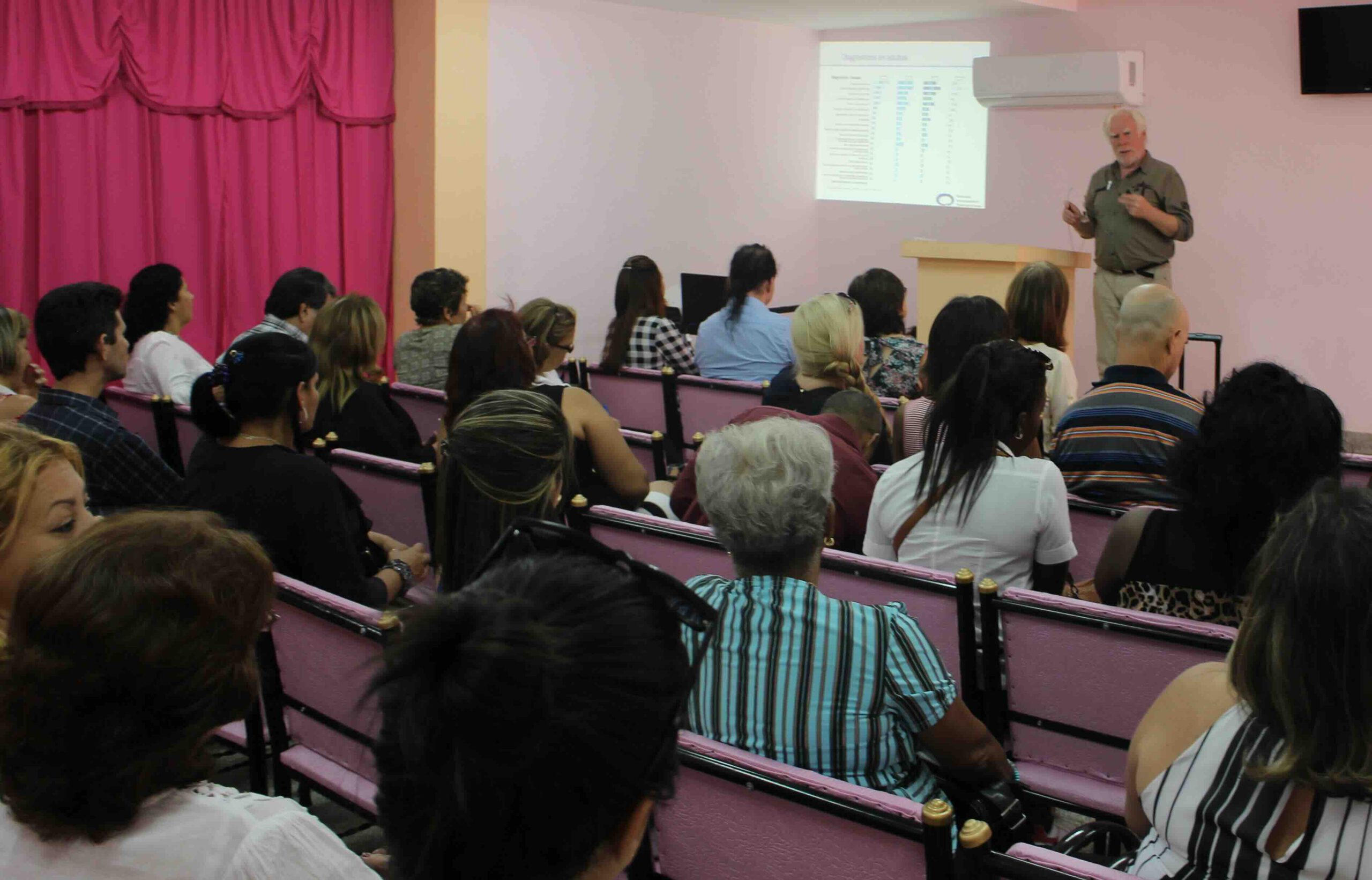 Vortrag im Rahmen des Kongresses für Psychosomatische Medizin in Santiago de Cuba, mit zahlreichen Teilnehmenden im Publikum.