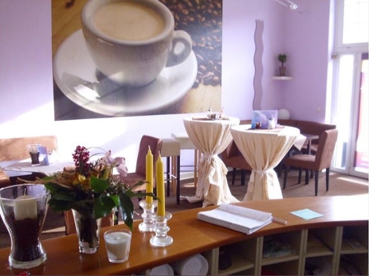Gemütliches Gesundheitscafé mit Tischen, Stühlen und Blumendekoration, Veranstaltungsort der Selbsthilfegruppe „Psychosomatische Erkrankungen“.