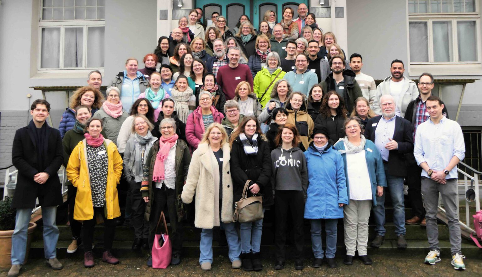 Gruppenfoto des gesamten Teams von Timmermann & Partner vor dem Praxisgebäude.